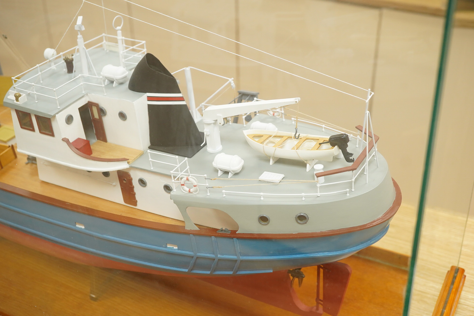 A model of a fishing trawler ship constructed from a kit by Billings Boats models, of painted wood construction, finished to a high standard with a good level of detail, presented in a glazed cabinet on a wooden base, ca